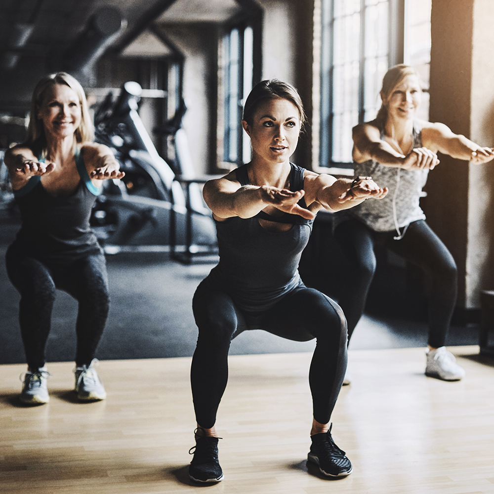 Drei Frauen trainieren individuell Ausdauer und Kraftaufbau im Fitnessstudio